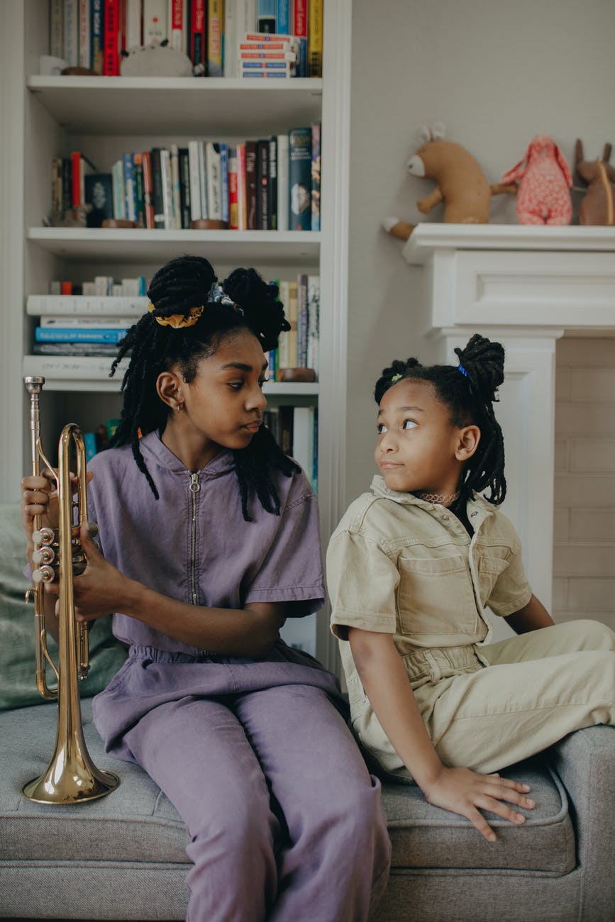 young girls sitting on the couch while looking at each other